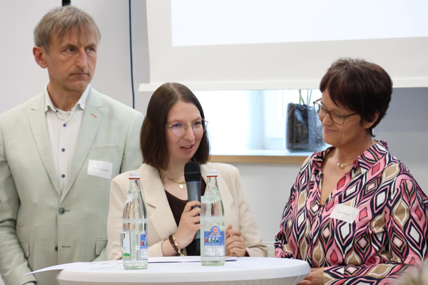 Ein Leistungsnehmerin des AAW spricht mit dem Mikrofon zum Publikum.